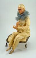 An unusual seated wax Pierrot doll on cushion, French, 1920’s,