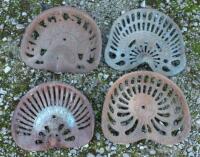 Four vintage iron tractor seats,