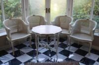 A set of four Louis XVI bergère giltwood chairs, with table ensuite