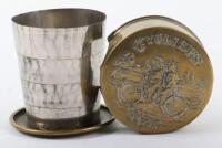 An Edwardian brass collapsible beaker, embossed tandem cycling scene