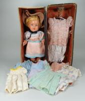 A hard composition baby doll with wardrobe, English 1950s,
