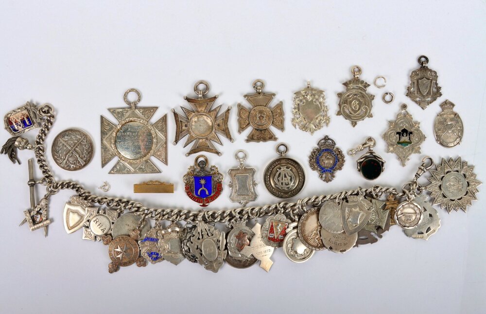A large silver chain with multiple silver fob medals and coins