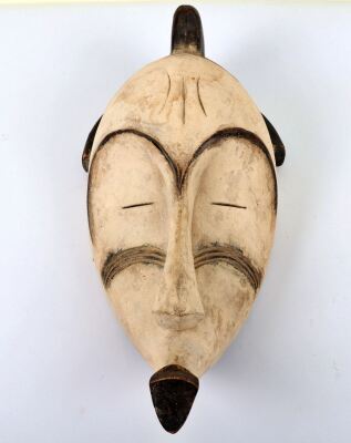 An African Fang funeral mask, typical white colour and carved features