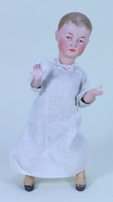 An unusual bisque head mechanical ‘walking’ doll, German circa 1910,