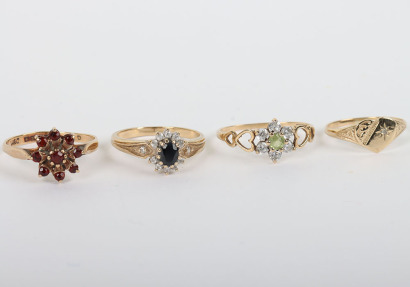 A group of four 9ct rings, including a 9ct ruby flower set ring, with a peridot and diamond ring, a sapphire and diamond ring and a 9ct signet ring,