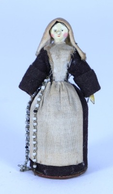 A sweet miniature painted wooden Grodnertal doll dressed as a Nun with pill box to skirt, German 1820s,