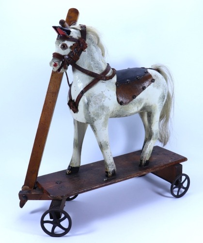 A painted carved wooden pull-along toy horse on wheels, English circa 1890,