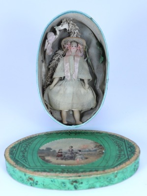 A rare and early bees wax shoulder head dolls house doll in original clothes and decorative oval box, English circa 1840,