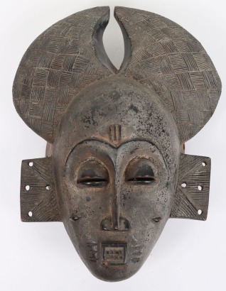 Carved and black stained wooden mask