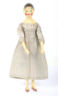 A rare and exquisite early painted carved wooden doll with her original extensive wardrobe, including seven gowns, nightdress and initialled undergarments, German circa 1810,
