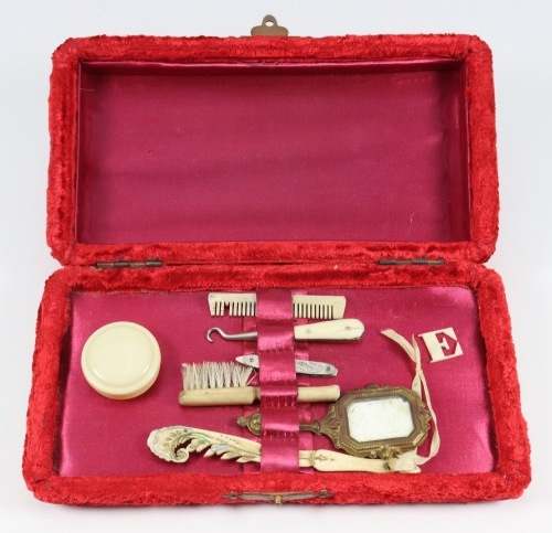 A good collection of miniature fashion doll accessories in a red velvet box, circa 1860,