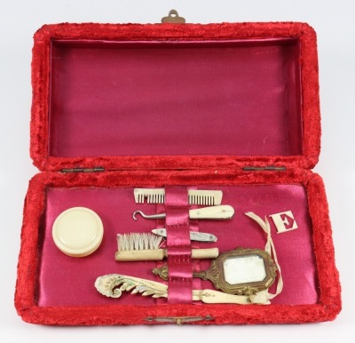 A good collection of miniature fashion doll accessories in a red velvet box, circa 1860,