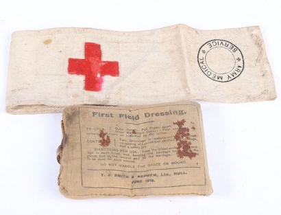 A WW1 First Field Dressing and RAMC Red Cross Armband.