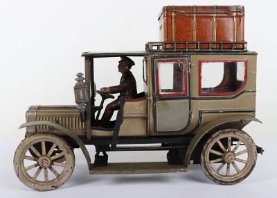 Carette tinplate clockwork Limousine, German circa 1909, finished in grey and black with cream lining and red window frames, roof with roof rack and running boards, hinged doors to rear, with glass windows, tinplate driver on padded style bench seat, two - 3
