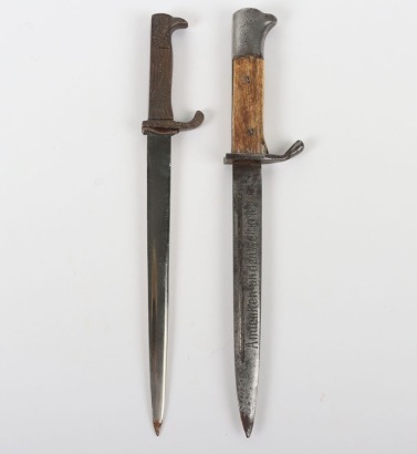 Miniature German K98 Bayonet, with wooden grips, blade engraved 'Andenken an den Weltkrieg'. No scabbard. Accompanied by a smaller bronze miniature of a German bayonet with oakleaves relief to the hilt and body. Also without scabbard. (2 items)