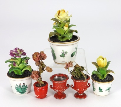 Three glazed china miniature flowers in plant pots,