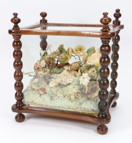 A religious scene in glazed case with wax baby and dove, southern European