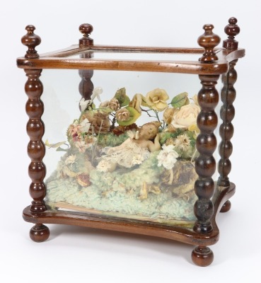 A religious scene in glazed case with wax baby and dove, southern European