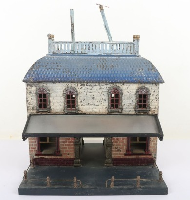 Bing 0 gauge Railway Station, brick effect building painted in shades of cream and orange, blue tiled effect roof, lithographed central arch and windows and glass tinplate framed canopy, 23.5cm wide, 22.5cm deep, 32cm high, fair condition, wear and paint 