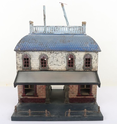 Bing 0 gauge Railway Station, brick effect building painted in shades of cream and orange, blue tiled effect roof, lithographed central arch and windows and glass tinplate framed canopy, 23.5cm wide, 22.5cm deep, 32cm high, fair condition, wear and paint 