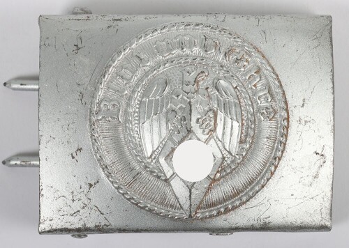 Third Reich Hitler Youth (Hitler Jugend) Belt Buckle by F.W. Assmann & S&ouml;hne, L&uuml;denscheid, stamped steel construction with central HJ eagle and diamond surrounded by the motto &ldquo;Blut und Ehre&rdquo;. Complete rarely encountered Assmann reverse set-up with integr