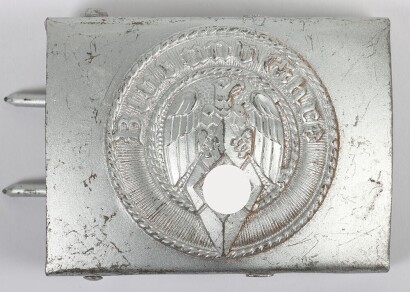 Third Reich Hitler Youth (Hitler Jugend) Belt Buckle by F.W. Assmann & S&ouml;hne, L&uuml;denscheid, stamped steel construction with central HJ eagle and diamond surrounded by the motto &ldquo;Blut und Ehre&rdquo;. Complete rarely encountered Assmann reverse set-up with integr