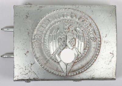 Third Reich Hitler Youth (Hitler Jugend) Belt Buckle by F.W. Assmann & S&ouml;hne, L&uuml;denscheid, stamped steel construction with central HJ eagle and diamond surrounded by the motto &ldquo;Blut und Ehre&rdquo;. Complete rarely encountered Assmann reverse set-up with integr