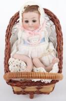 Miniature all-bisque baby doll in pram,