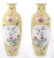 A pair of Chinese famille rose yellow-ground vases, Qianlong mark, 19th/20th Century