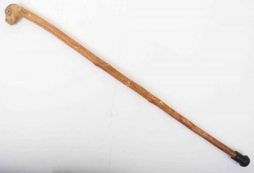 A rustic carved grotesque mask walking stick