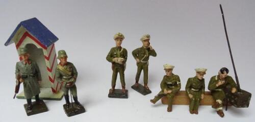 Arnold 70mm, three composition Military Police peak caps, with two RARE similar standing figures, a wooden Sentry Box and two Lineol Wehrmacht figures (Condition Very Good) (8)