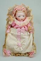 A reproduction bisque head baby in papoose,